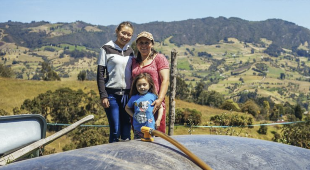 Two women and a child with a biodigester in Mexico