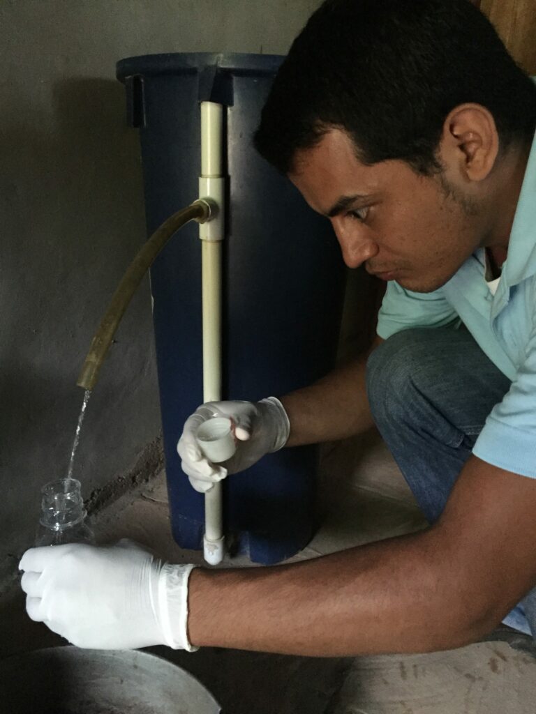 A man pours clean drinking water from a filtered container in Honduras